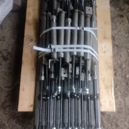 Pakiet siłowników hydraulicznych, zabezpieczonych taśmami zaciskowymi, ułożonych na drewnianej palecie.