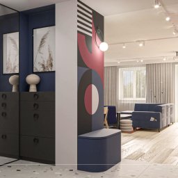 Projekt 5R - Wnętrze mieszkania z szafą wnękową z lustrzanymi drzwiami, ciemnymi frontami i okrągłymi uchwytami, obok ściana z geometrycznym malunkiem w kolorach czerwonym, czarnym i białym, widoczny fragment...