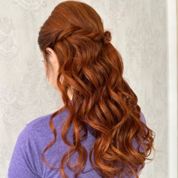 ZmalowAna by Anna Prażmo - Rude włosy upięte w romantyczną fryzurę z warkoczem i lokami, widok z tyłu na tle jasnej ściany. Subtelne upięcie na specjalną okazję.