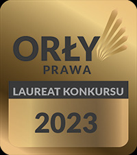 Złota odznaka 'Orły Prawa - Laureat Konkursu 2023' z czarnym napisem na szarym tle, symbolizująca nagrodę prawniczą.