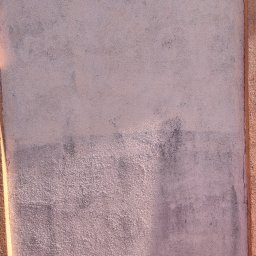 DreamClean Sp. z o.o. - Fragment ściany zewnętrznej z nierównomiernie nałożoną, różową farbą, widoczne ślady zabrudzeń i różnice w odcieniach.