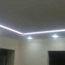 Nowoczesny sufit podwieszany z oświetleniem LED w mieszkaniu w Łodzi, z widocznymi punktowymi źródłami światła i listwą LED wzdłuż krawędzi.