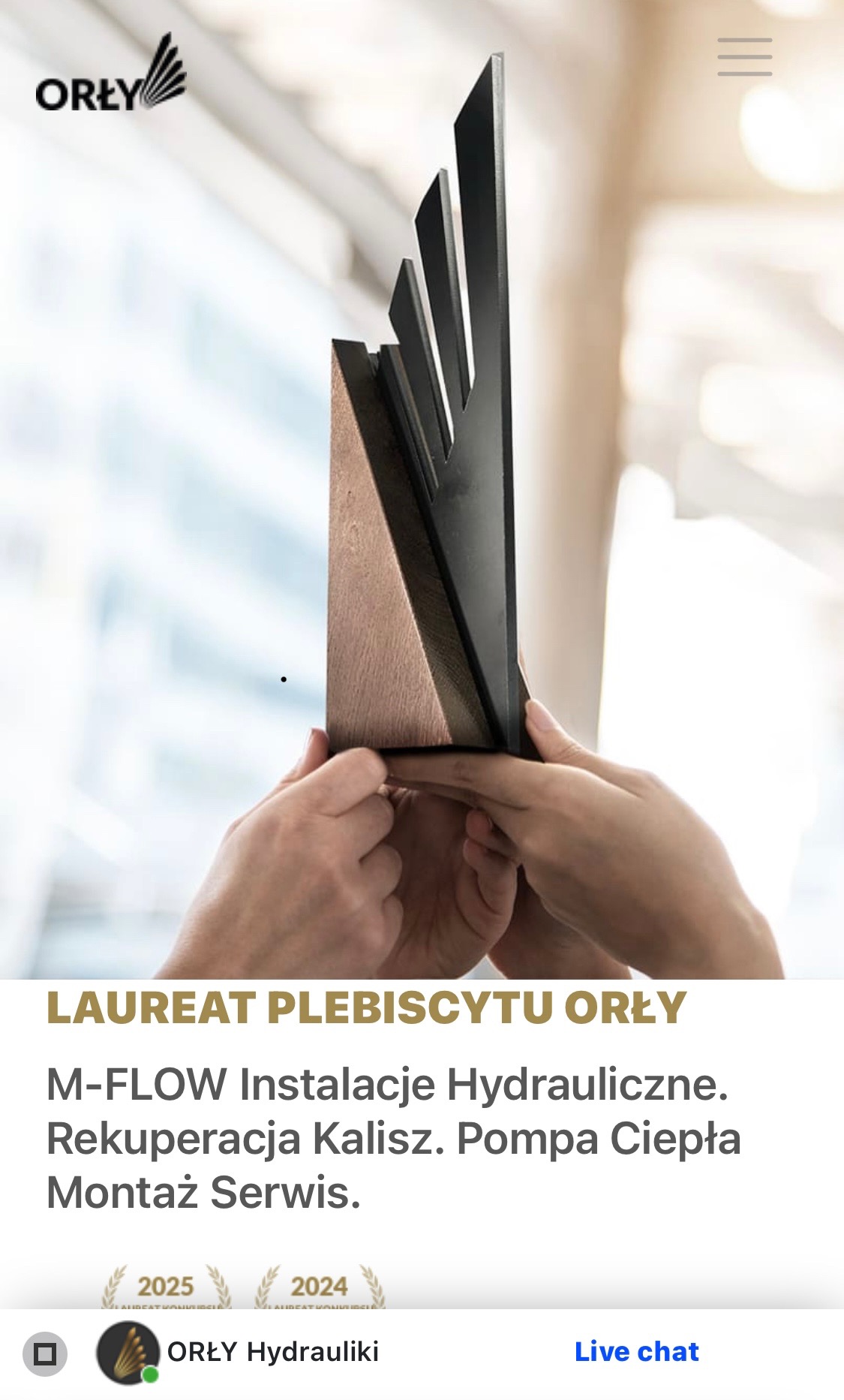 Wręczenie nagrody 'Orły' dla M-FLOW Instalacje Hydrauliczne z Kalisza za rekuperację i montaż pomp ciepła. Prezentacja statuetki w dłoniach.