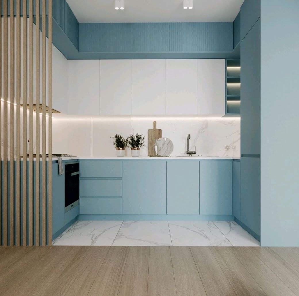 Nowoczesna kuchnia w odcieniach błękitu i bieli z marmurowym blatem i drewnianą podłogą, oddzielona ażurową ścianką działową.
