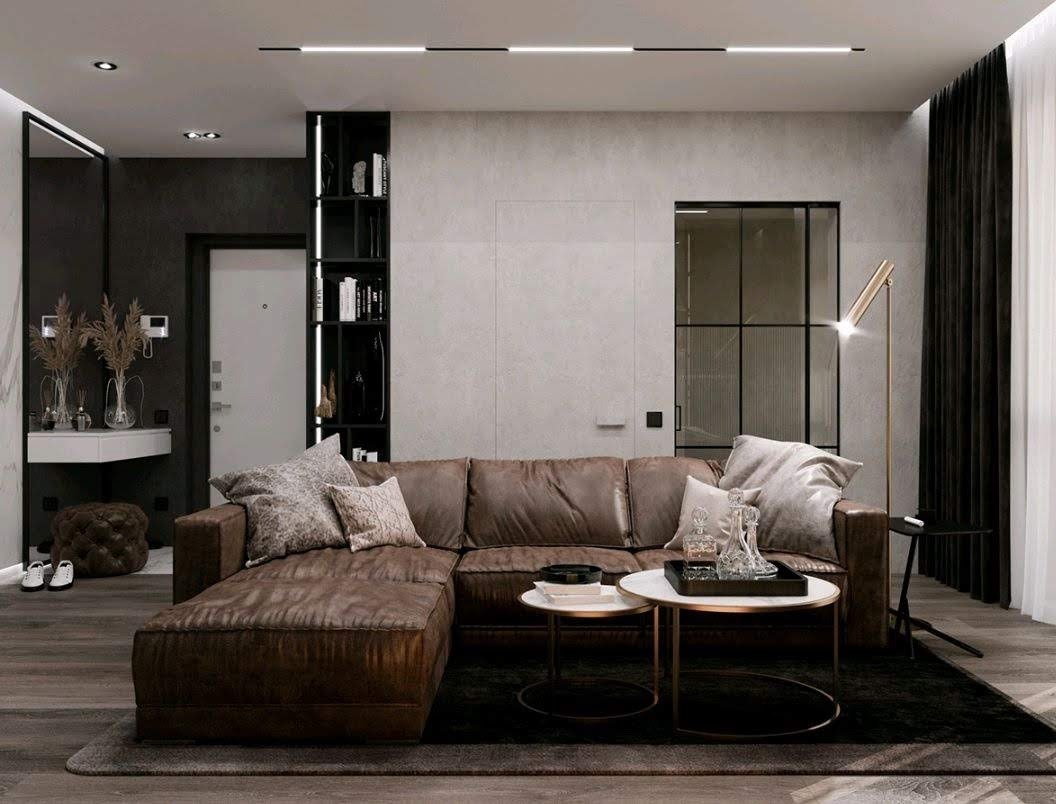 Elegancki salon w odcieniach szarości i brązu z narożną sofą ze skóry, okrągłymi stolikami kawowymi i minimalistycznym oświetleniem LED na suficie.