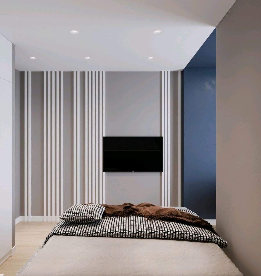 Nowoczesna sypialnia z telewizorem na szarej ścianie z białymi pionowymi panelami, łóżko z beżową pościelą i czarno-białą narzutą w paski, oświetlenie punktowe w suficie.