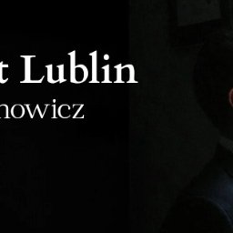 Kancelaria Adwokacka Igor Achrymowicz - Portret profilowy adwokata w garniturze, z okularami, spoglądającego przez okno. Po lewej stronie widnieje napis 'Adwokat Lublin Igor Achrymowicz'.