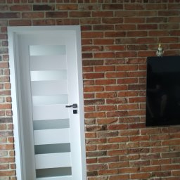 A.W. Construction Ariel Włodarczyk - Ułożona cegiełka na ścianie w salonie - widok po remoncie generalnym mieszkania.