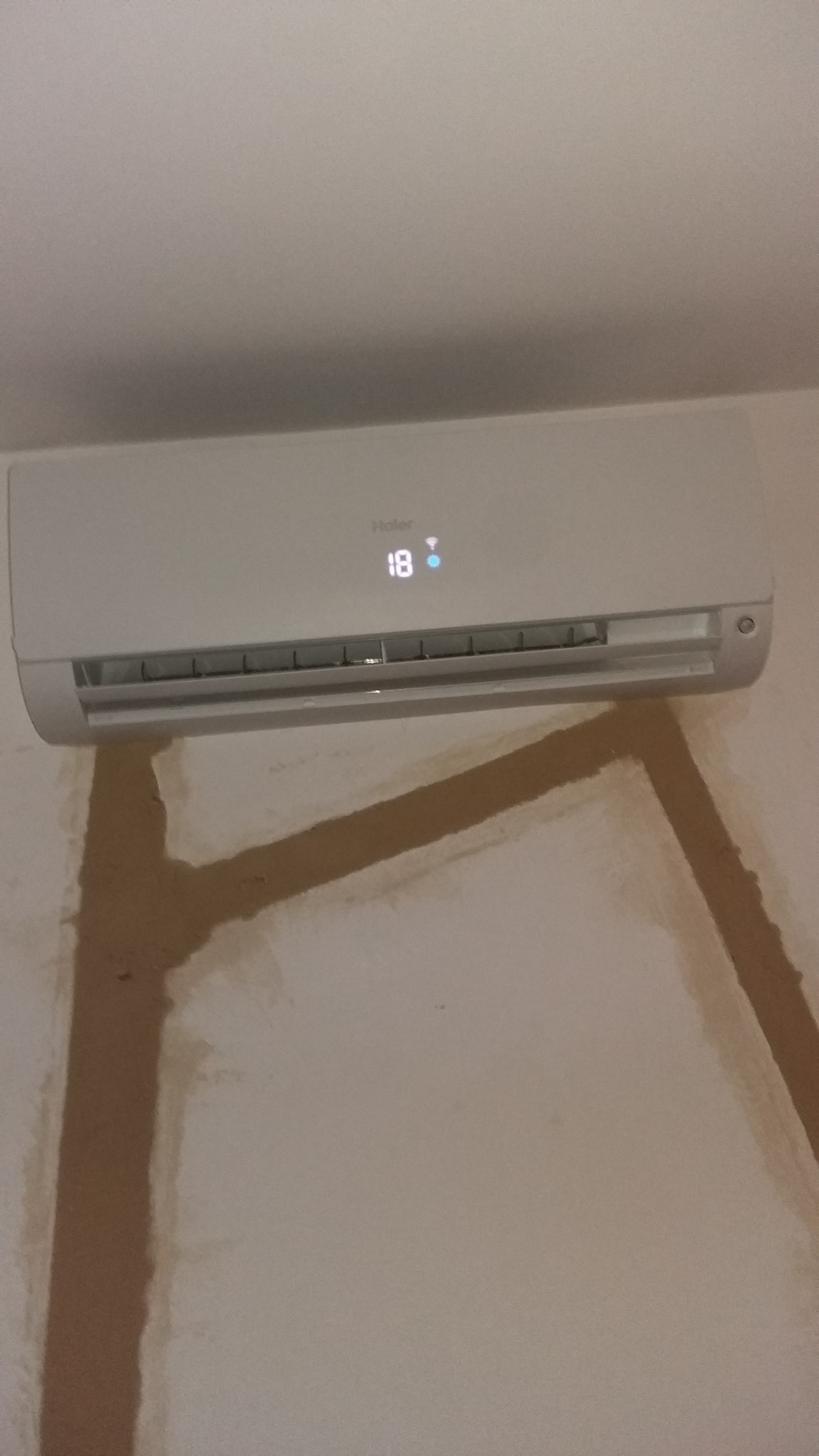 Zamontowana jednostka wewnętrzna klimatyzacji Haier w Poznaniu, widoczne ślady po montażu na ścianie, ustawiona temperatura 18 stopni.