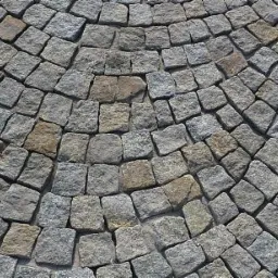 Ułożona nawierzchnia z szarej kostki granitowej w kształcie wachlarza, widoczne nieregularne spoiny i naturalna kolorystyka kamienia.