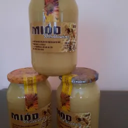 Trzy słoiki wielokwiatowego miodu z pasieki Wojciecha Janickiego, ułożone jeden na drugim, z widocznymi etykietami informującymi o dacie przydatności do spożycia i masie netto.