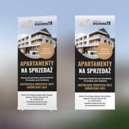 Dwa roll-upy reklamowe apartamentów na sprzedaż w Krynicy Morskiej, prezentujące wizualizację budynku i informacje o inwestycji.