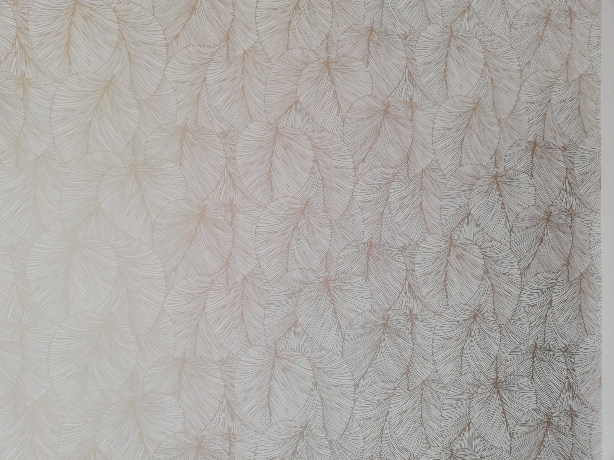 Ściana pokryta tapetą z delikatnym wzorem liści w odcieniach beżu i bieli, tworząca subtelny, naturalny efekt.