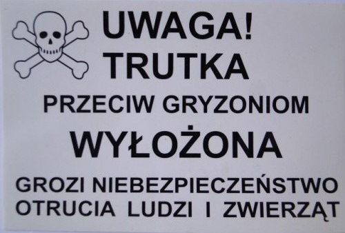 Tabliczka ostrzegawcza informująca o wyłożonej trutce na gryzonie, z symbolem czaszki i skrzyżowanych kości, ostrzegająca przed niebezpieczeństwem otrucia ludzi i zwierząt.