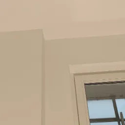 Pomieszczenie po malowaniu, widoczny fragment ściany, sufitu i okna z białymi ramami. Ściany i sufit pomalowane na jasny, kremowy kolor.