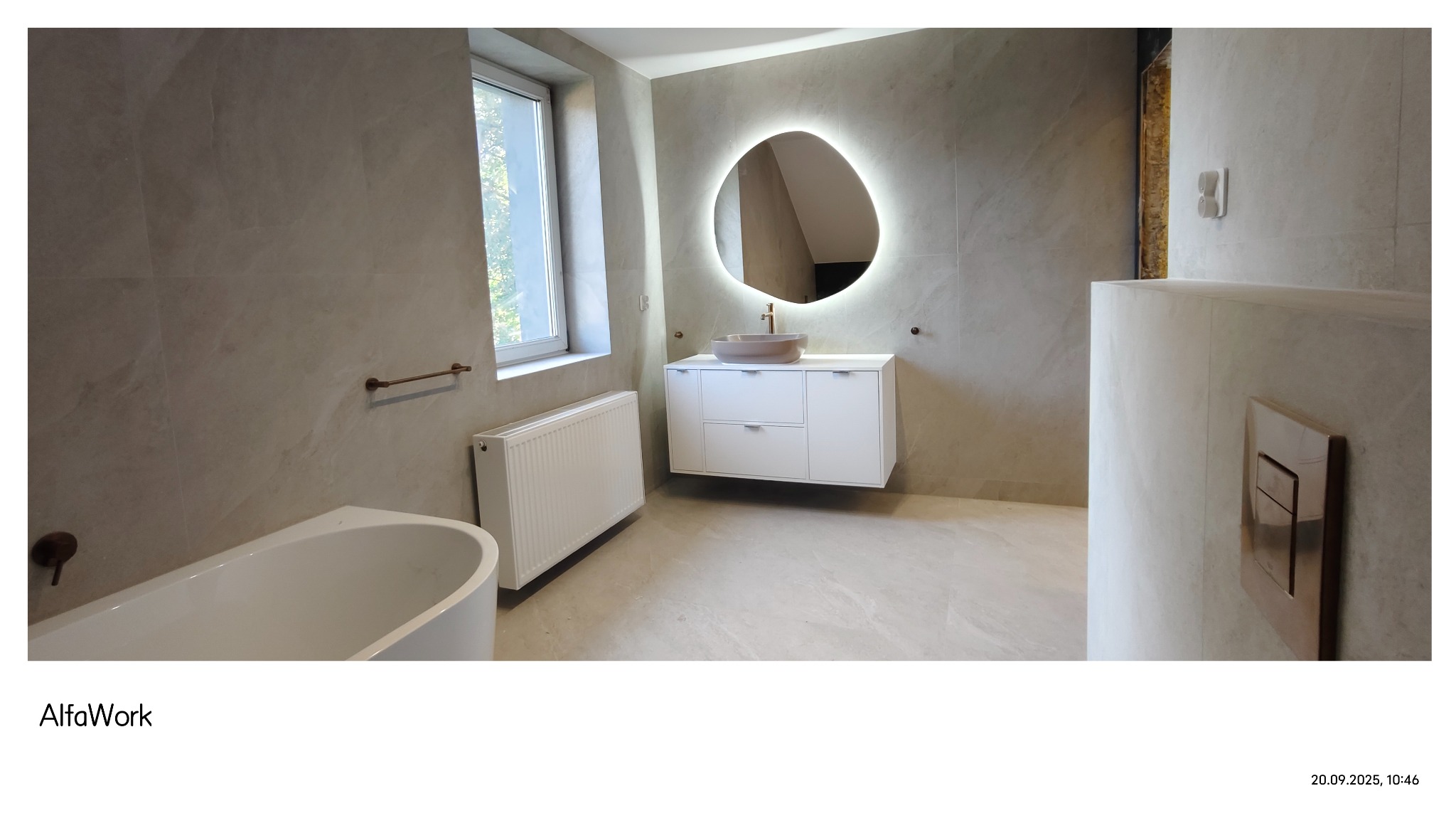 Elegancka łazienka w beżowych tonacjach z podświetlanym lustrem, białą szafką pod umywalką i grzejnikiem. Uwagę zwraca designerska armatura i minimalistyczny styl.