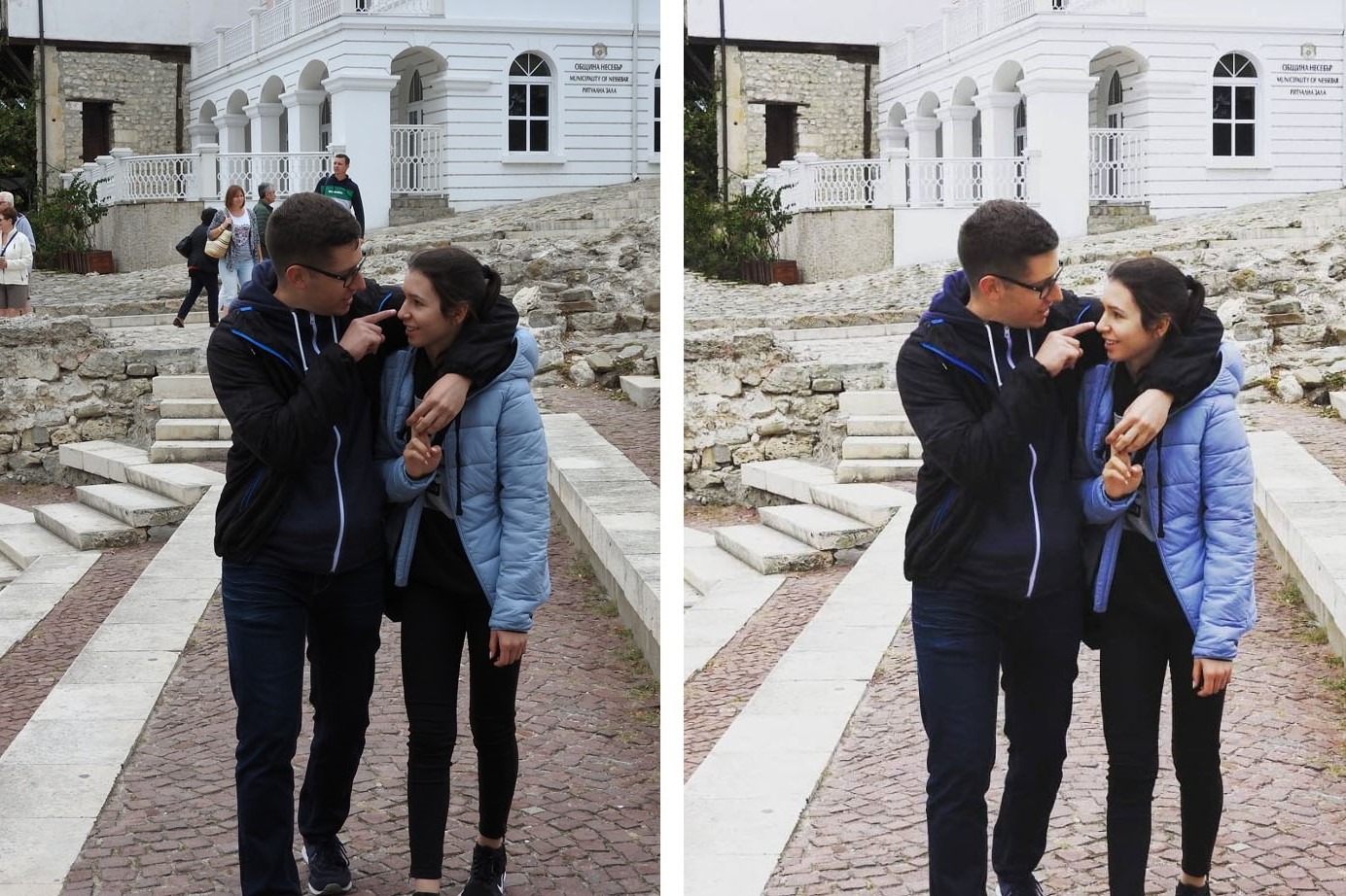 Para młodych ludzi w okularach, spacerujących po brukowanej ulicy z kamiennymi schodami i budynkiem w tle, mężczyzna dotyka palcem nosa kobiety.