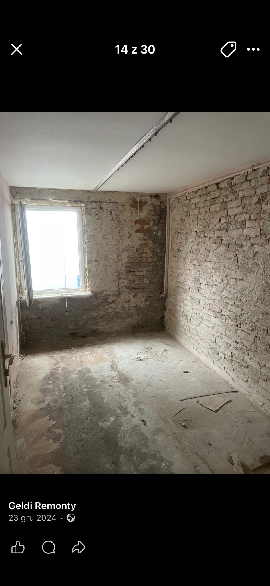 Wnętrze pokoju w trakcie remontu: odsłonięta cegła na ścianach, surowy beton na podłodze, okno z widokiem na zewnątrz. Widoczne ślady po starych instalacjach.