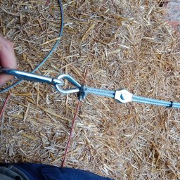 BW-Computers Bogusz Wawrzyniak - Montaż liny stalowej z zaciskiem i karabińczykiem na tle słomy.