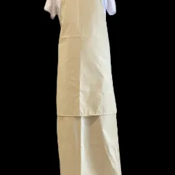 Beżowy, długi fartuch roboczy z dodatkową warstwą ochronną od pasa w dół, zawieszony na białej koszulce, widoczne oznaczenie CE na górze.