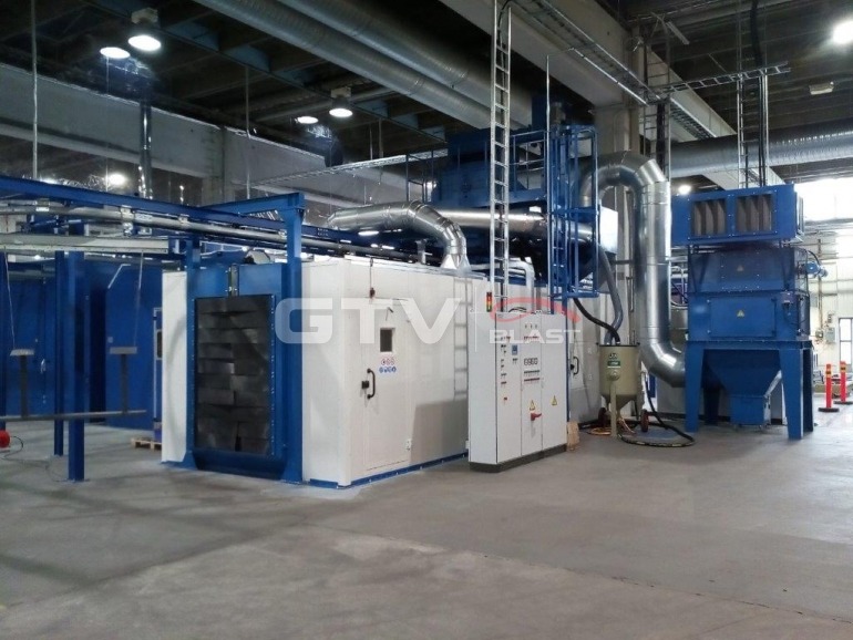 Kompleksowa linia technologiczna z kabiną lakierniczą i stanowiskiem doczyszczania, widoczne elementy instalacji, rurociągi, szafa sterownicza i drabina, w hali przemysłowej.