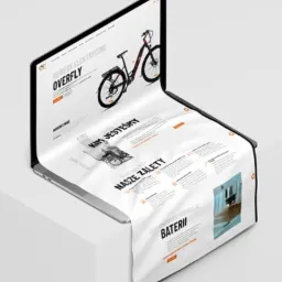 Mockup strony internetowej z rowerem elektrycznym marki Overfly, wyświetlany na laptopie, którego ekran płynnie przechodzi w białe tło z elementami projektu.