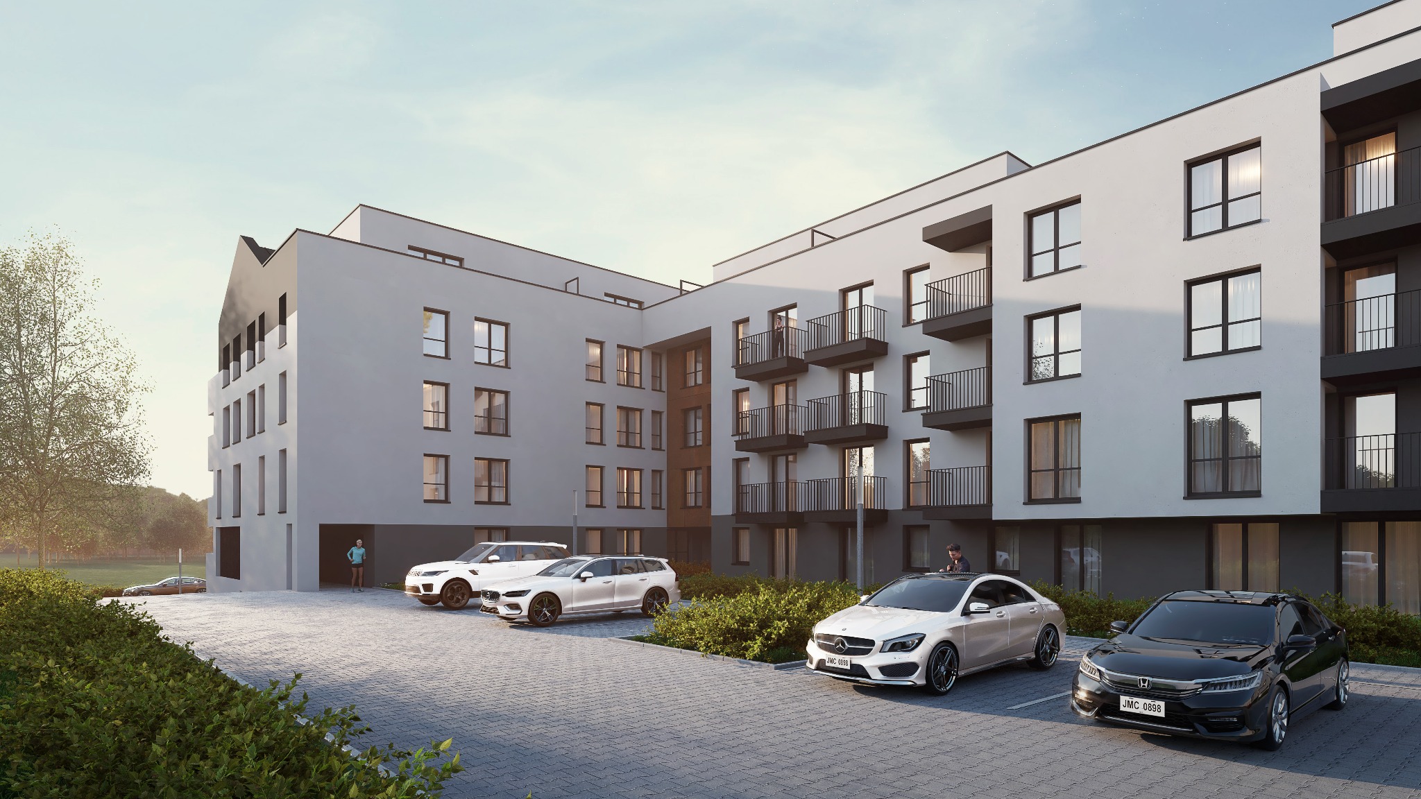 Nowoczesny, wielorodzinny budynek mieszkalny z balkonami i miejscami parkingowymi, otoczony zielenią i z widocznymi osobami w tle.