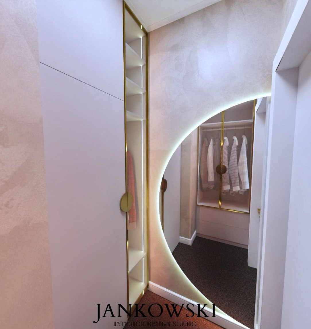 Nowoczesna garderoba z oświetleniem LED i lustrem w kształcie łuku, białe szafy z złotymi akcentami, widok na wnętrze garderoby. Minimalistyczny design.