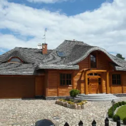 Gotowy dom z drewnianych bali z oryginalnym dachem krytym gontem, widok z zewnątrz na starannie zagospodarowany teren.