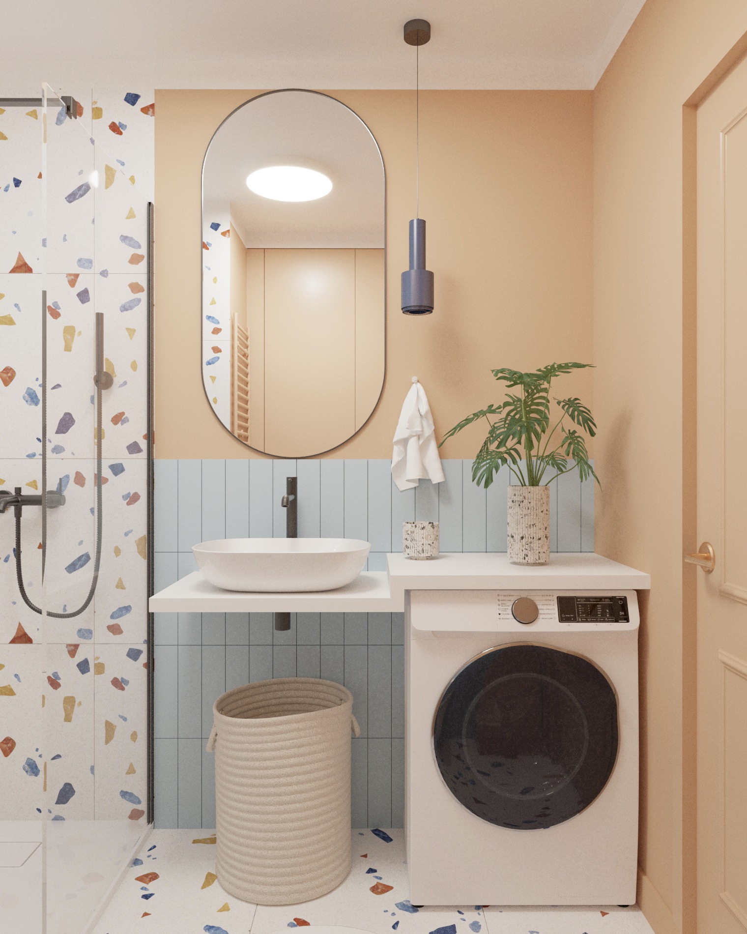 Nowoczesna łazienka z umywalką nablatową, pralką, lustrem o zaokrąglonym kształcie i płytkami w stylu terrazzo, oświetlona wiszącą lampą.