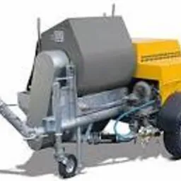 Agregat tynkarski, widok z boku, z widocznym zbiornikiem w kolorze szarym i elementami w kolorze żółtym. Urządzenie na kołach, z dyszami i wężami.