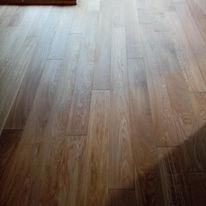 Ułożona podłoga z paneli imitujących drewno, widoczne delikatne przejścia kolorystyczne i struktura słojów.