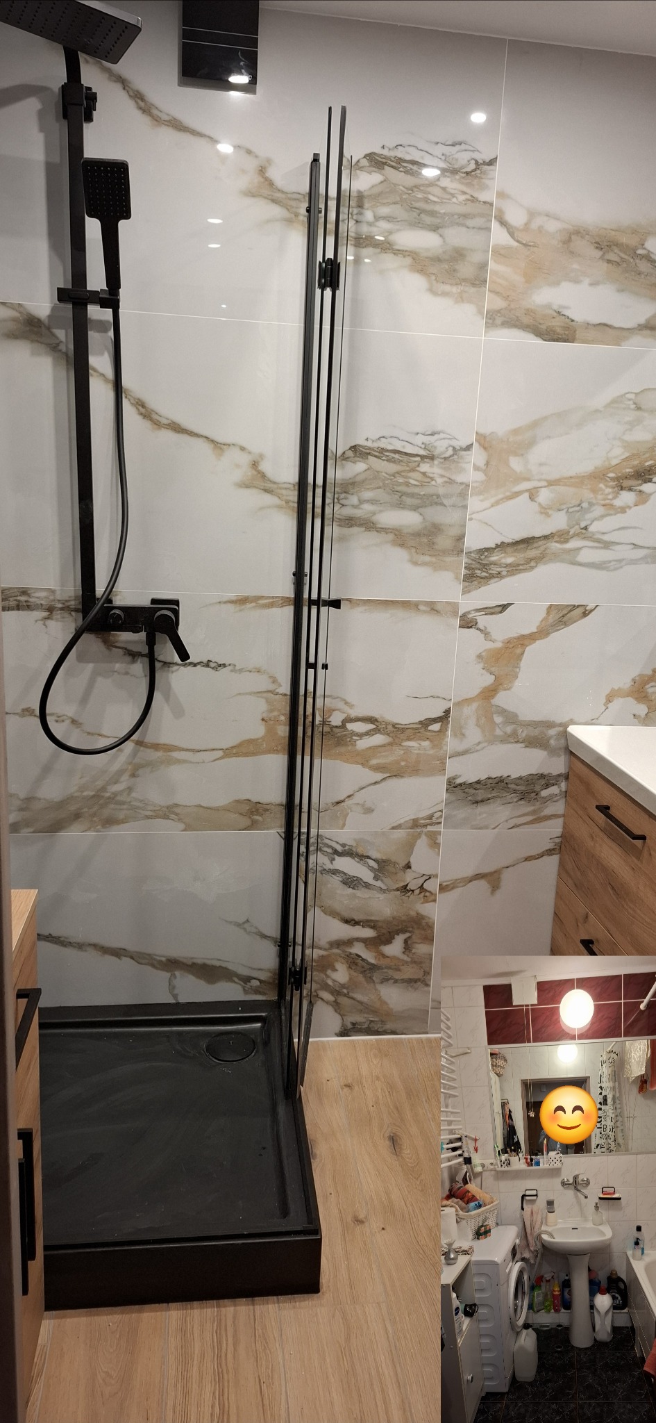 Nowoczesna kabina prysznicowa z czarnym brodzikiem i armaturą na tle płytek imitujących marmur, widok na fragment szafki umywalkowej z drewnianym frontem oraz odbicie w lustrze pokazujące drugą...