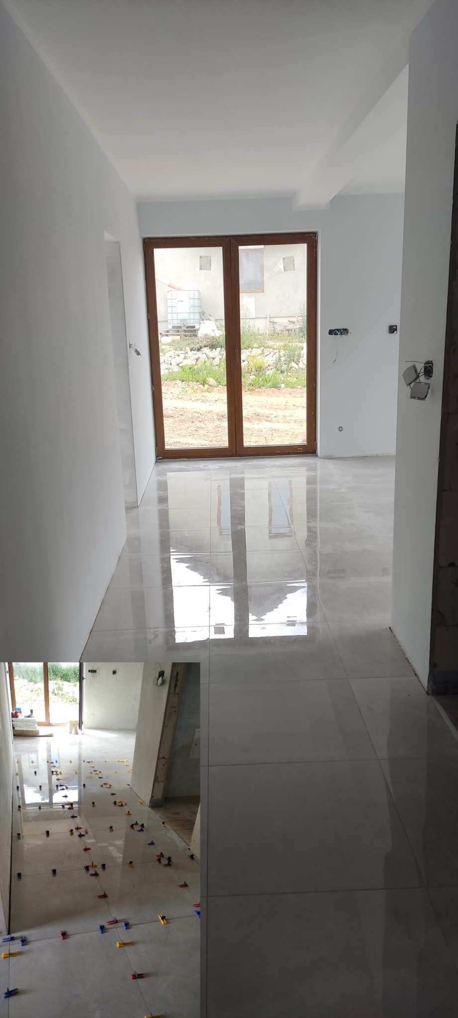 Układanie jasnych, błyszczących płytek podłogowych w nowym domu, widoczne krzyżyki dystansowe, duże okno z widokiem na ogród.