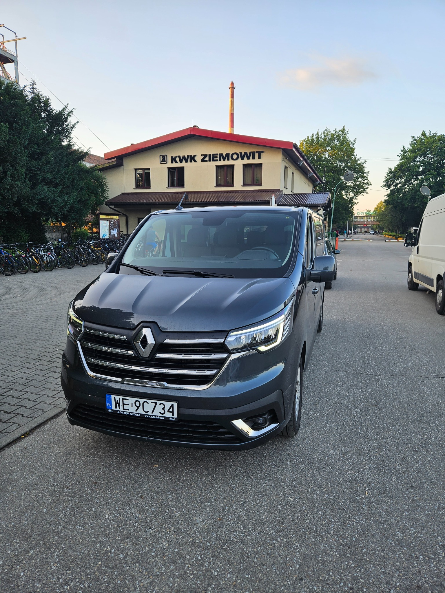 Szary van Renault z polską tablicą rejestracyjną WE 9C734 zaparkowany przed budynkiem KWK Ziemowit