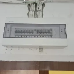 Rozdzielnica elektryczna firmy Elektro-Plast z czternastoma bezpiecznikami Eaton, zamontowana na ścianie z widocznymi przewodami wchodzącymi od góry.