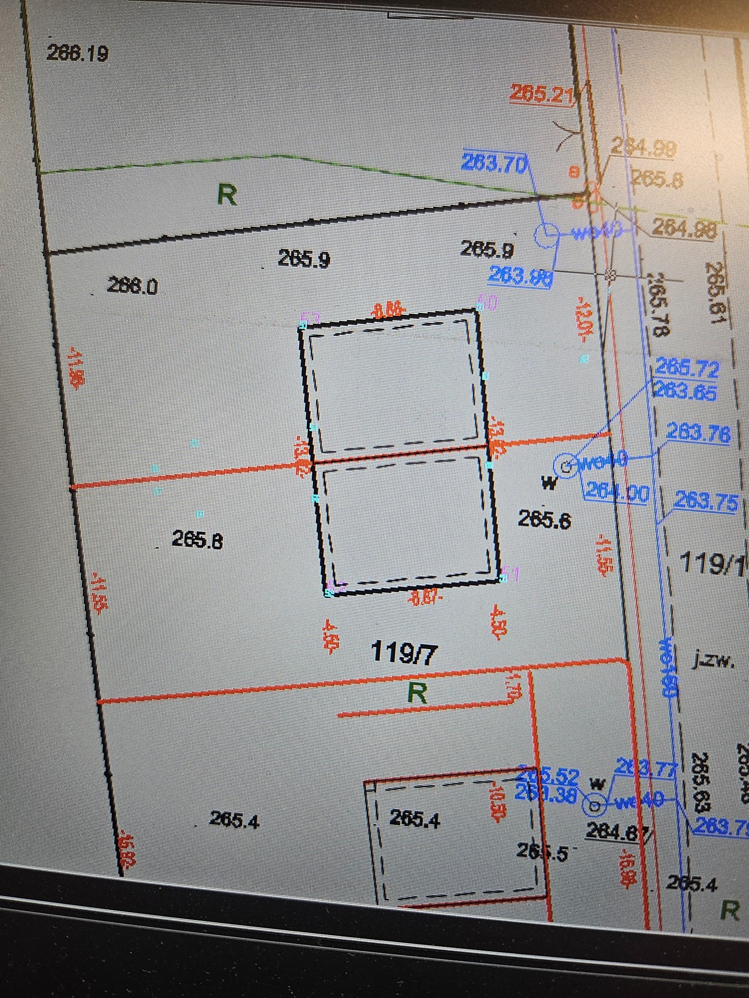 Skan mapy geodezyjnej z naniesionymi numerami działek, granicami i wysokościami terenu. Widoczne linie, punkty pomiarowe i oznaczenia, w tym numery działek 119/1 i 119/7.
