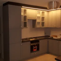 Szara kuchnia na wymiar z oświetleniem LED podszafkowym, czarnym blatem i drewnianą podłogą, widok na zabudowę kuchenną z piekarnikiem i górnymi szafkami z przeszklonymi frontami.