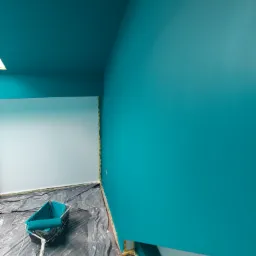 Świeżo pomalowane na turkusowo ściany i sufit w pomieszczeniu w Gliwicach, z widocznym wałkiem i kuwetą malarską na folii ochronnej.