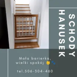 Drewniana barierka zabezpieczająca schody, z białymi szczebelkami i jasnym drewnem, zamontowana na drewnianych schodach w białym wnętrzu.