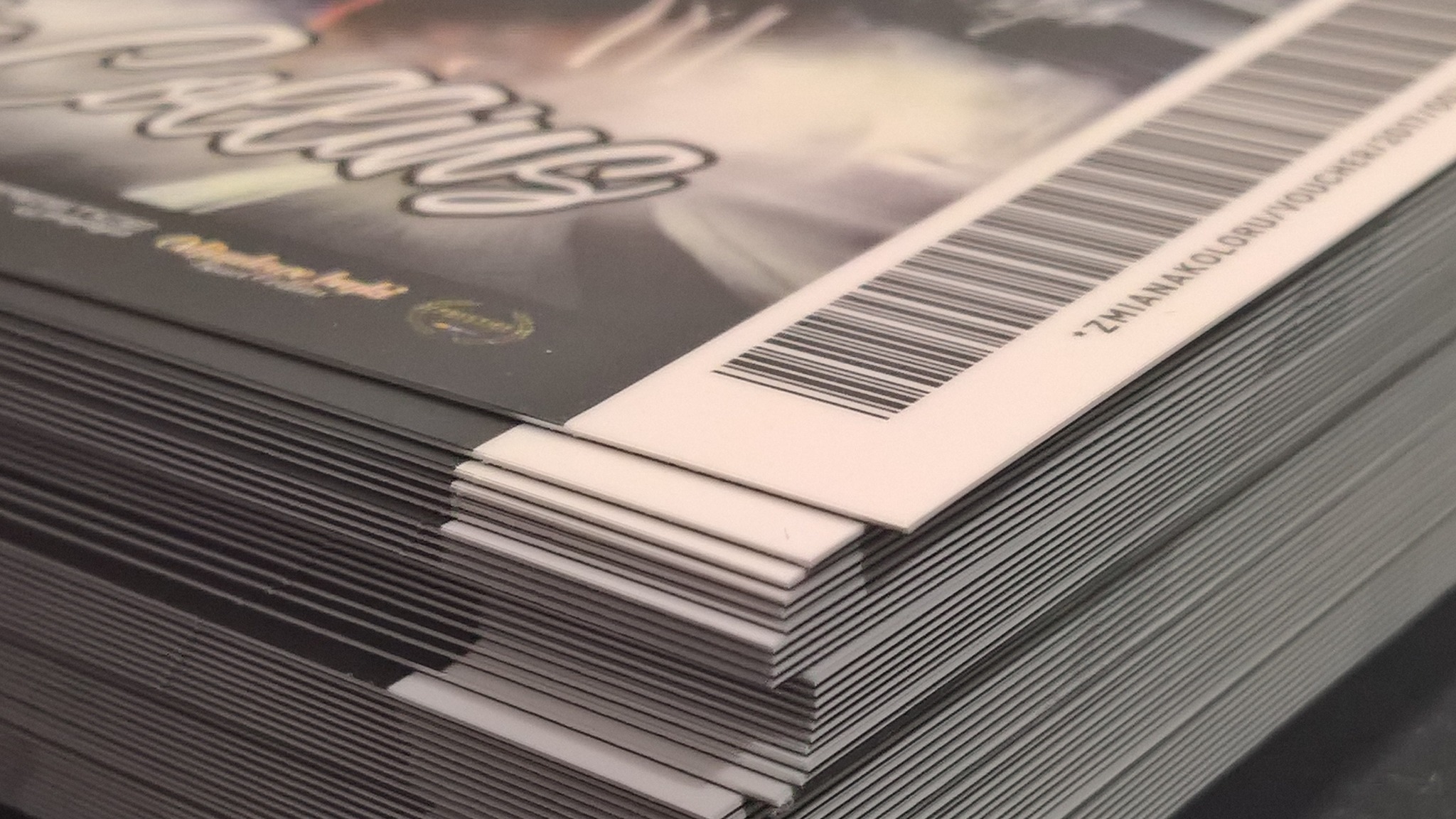 Stos czarno-białych kart z kodem kreskowym, prawdopodobnie kuponów rabatowych, ułożonych równo jeden na drugim.
