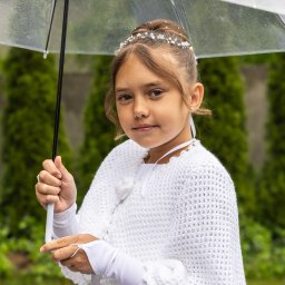 Michał Ciepielowski Dziki kadr - Dziewczynka w białej sukience i z przezroczystym parasolem na tle zieleni, pozująca do zdjęcia komunijnego w plenerze.