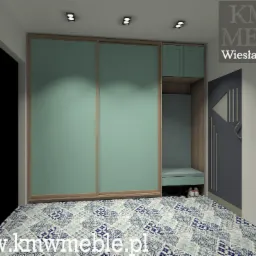 Wizualizacja szafy wnękowej z przesuwnymi drzwiami w kolorze miętowym, siedziskiem i szafkami, na podłodze wzorzyste płytki, logo firmy KM Meble w prawym górnym rogu.