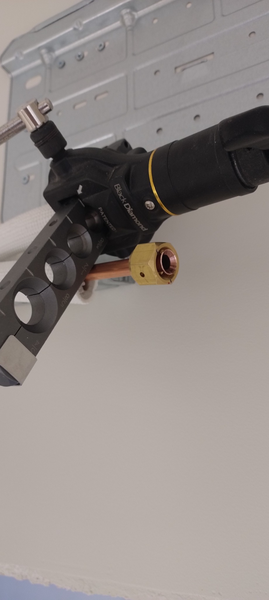 Podłączenie miedzianej rurki do klimatyzacji za pomocą narzędzia Black Diamond, widoczne otwory o różnych średnicach.