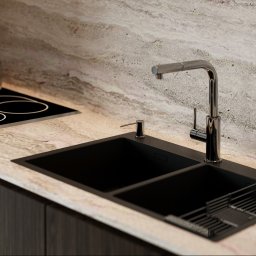 Visual Home Iryna Protsyk - Nowoczesna kuchnia: czarny zlew z ociekaczem i chromowaną baterią na blacie z kamienia, płyta indukcyjna i garnek w tle. Elegancki design z ciemnymi frontami szafek.