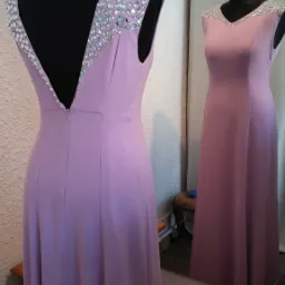 Liliowa suknia wieczorowa z kryształkami na ramionach, widok z tyłu na manekinie, odbicie sukni w lustrze.