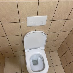 Clean Paradise - Biała toaleta marki Koło z otwartą klapą, widok z góry na tle beżowych płytek