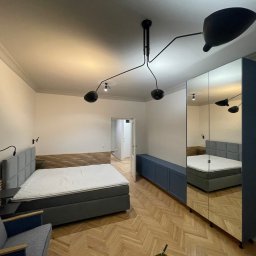 Sypialnia w mieszkaniu. Listwy sufitowe malowane w kolorze sufitu. 