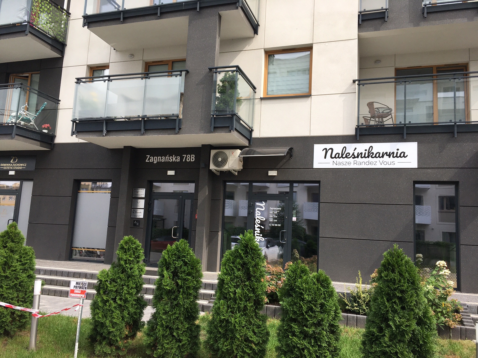 Fasada budynku z szyldem 'Naleśnikarnia - Nasze Randez Vous' i adresem Zagnańska 78B, z małymi drzewkami iglastymi przed wejściem i balkonami na wyższych piętrach.
