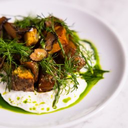 Salute - Wykwintna kompozycja kulinarnej kreacji: pieczone warzywa z truflami i świeżym koperkiem na kremowym sosie, podane na białym talerzu. Elegancka prezentacja dania.